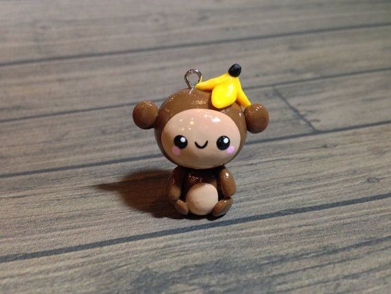 a small toy monkey with a yellow star on its head sitting on a wooden floor