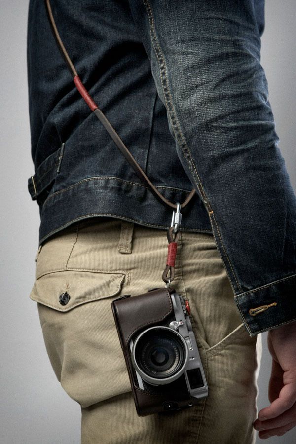 a man is holding an old camera in his pocket