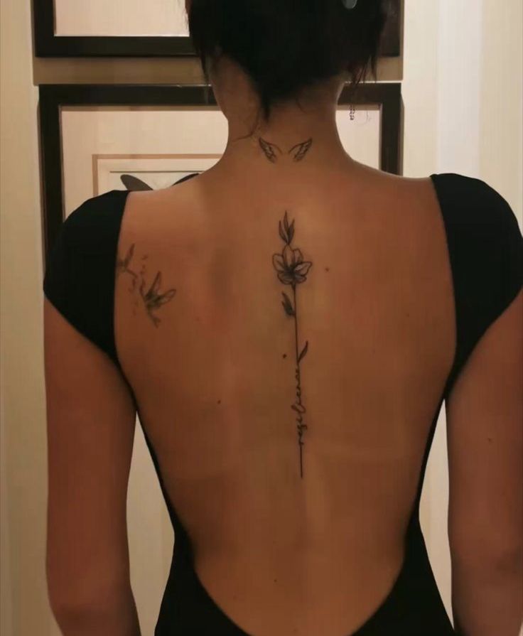 the back of a woman's body with tattoos on her upper and lower back