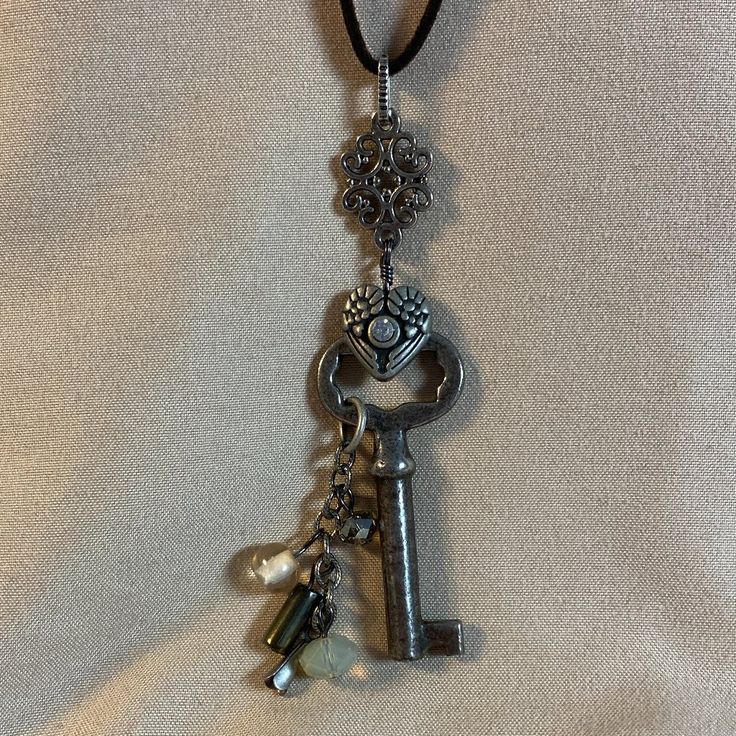 I Am Listing A Few Key Necklaces That Are Similar - This One Is Number 6. All Of Them Are Unique. This Is An Antique Key That Is On A Brown Suede Cord With A Cluster Of Beads. I Used Antiqued Silver Colored Charms And Links To Create This Necklace. Beads Are Crystal And Also Luster Finish Glass. This Is A New Item And Never Worn. The Key Pendant Portion Is 3 Inches Long And The Cord Is About 25 Inches Long Antique Key Necklace, Key Necklaces, Key Jewelry, Antique Keys, Necklace Beads, Number 6, Pendent Necklace, Suede Cord, Key Necklace