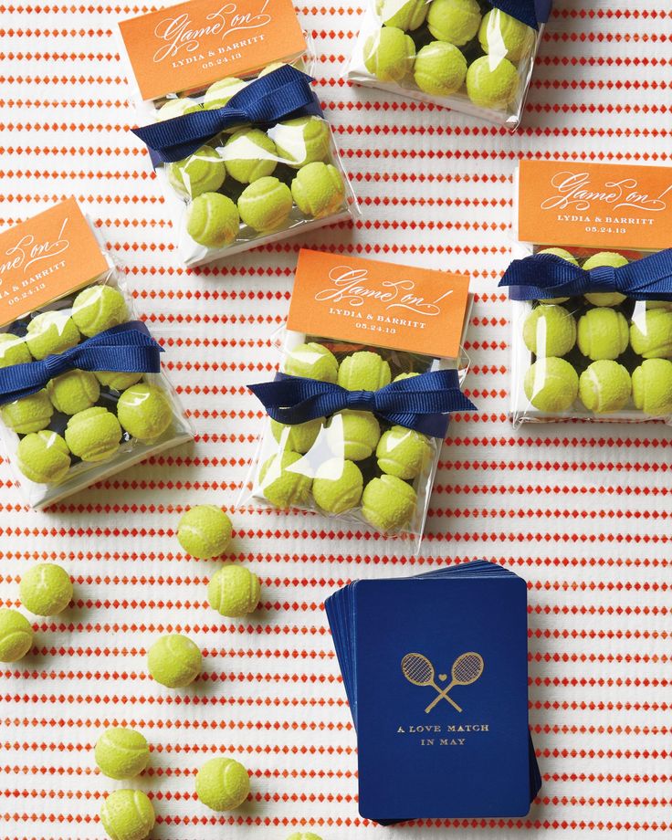 tennis balls are wrapped in cellophane and tied with a blue ribbon to match the table