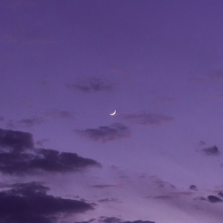 the moon is shining in the purple sky