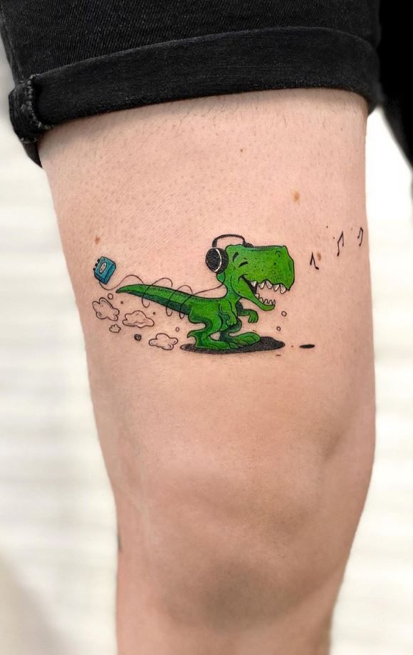 a person with a green dinosaur tattoo on their leg