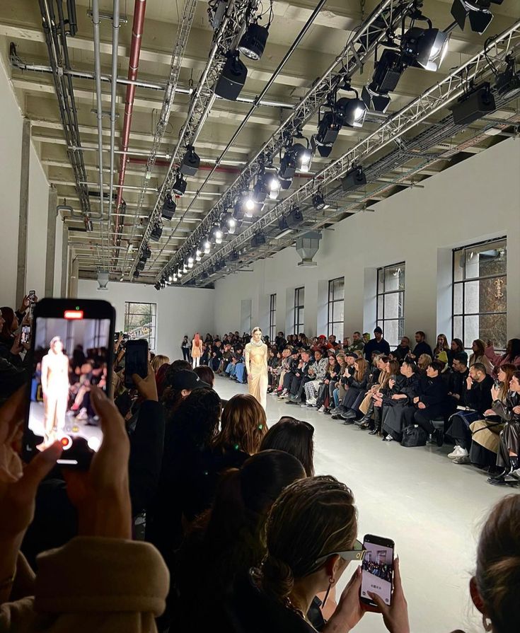 a crowd of people taking pictures of a fashion show