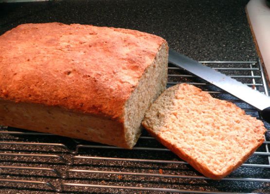 a loaf of bread sitting on top of a grill next to a slice of bread