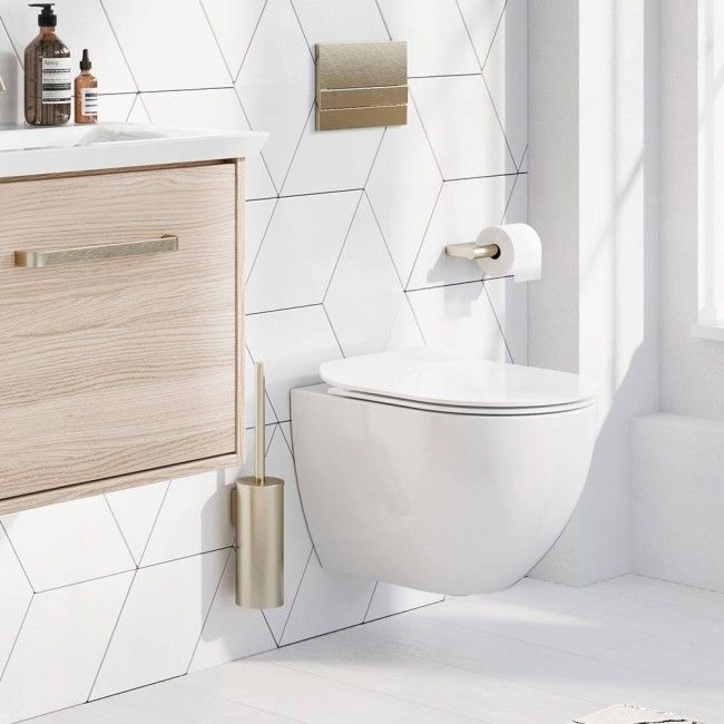 a white toilet sitting next to a sink in a bathroom under a window with wooden accents