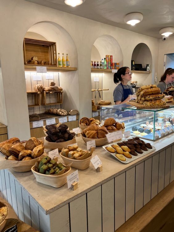 a bakery filled with lots of different types of breads and pastries on display