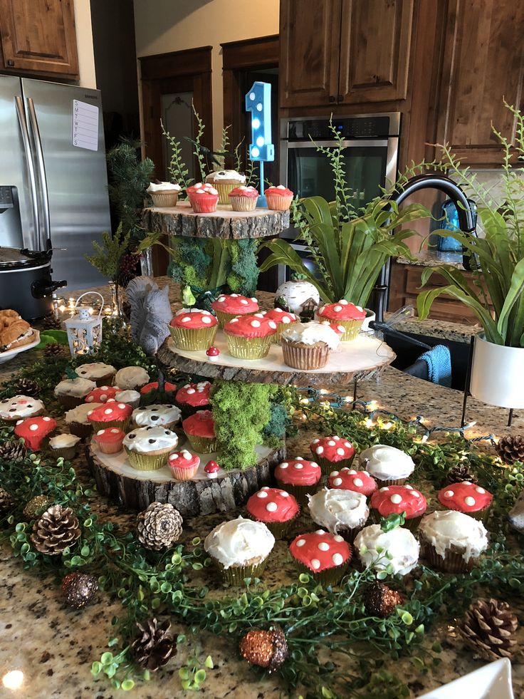 an assortment of cupcakes and muffins on a table in a kitchen