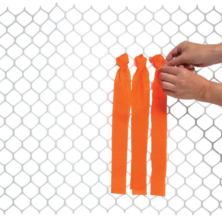 someone is holding some orange ribbon in front of a chain link fence with white background