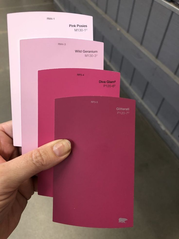 a person holding some pink paint samples in their hand