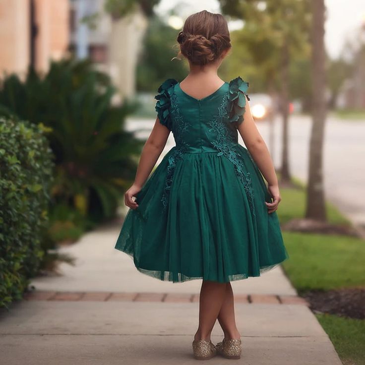 Fit for a princess, this dress has it all. Soft emerald satin graced with a touch of lace, this dress is a showstopper! Sleeves are embellished with whimsical die cut flowers that will have all eyes on her. Tulling overlay skirt adds just the right touch of fullness and twirl. Fully lined with soft cotton, back zip. 100% poly self, 100% cotton lining. Machine wash, hang dry. Bianca Dress, Overlay Skirt, All Eyes, Hanging Dryer, A Princess, Cut Flowers, All About Eyes, Fall Dresses, Graduation Dress