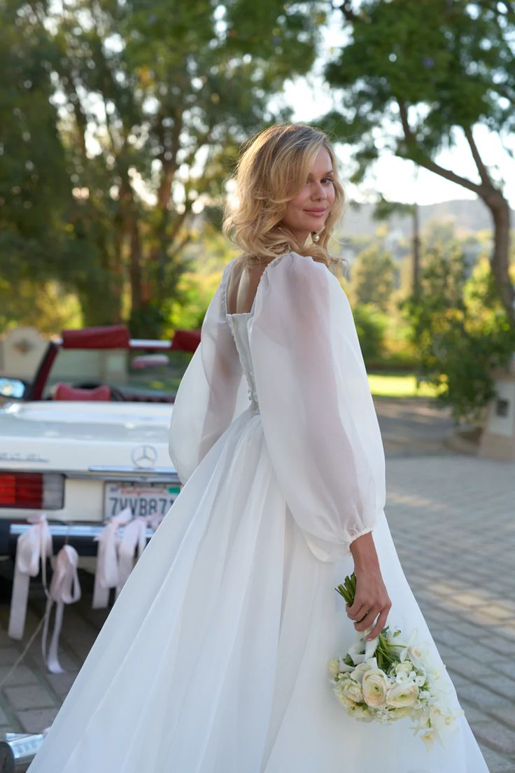 a woman in a white dress holding a bouquet