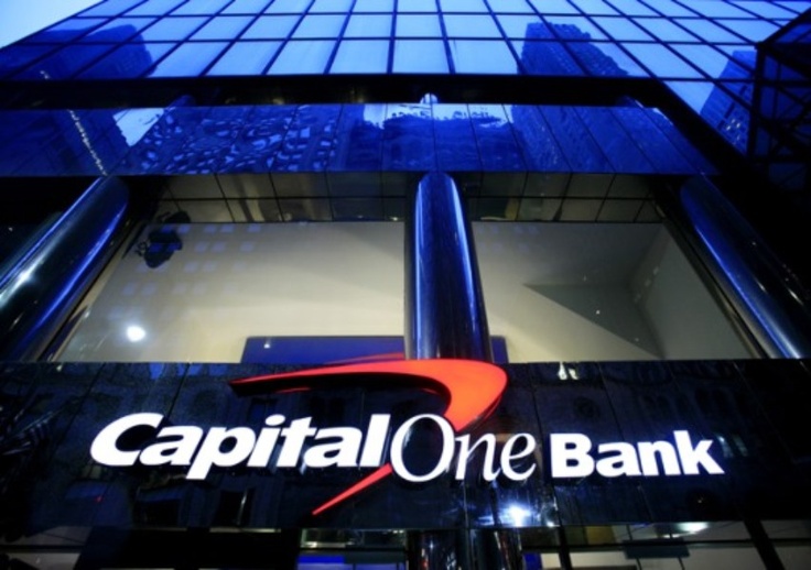 the capital one bank logo is shown in front of a glass building with skyscrapers