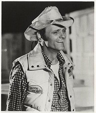 a man wearing a cowboy hat and vest