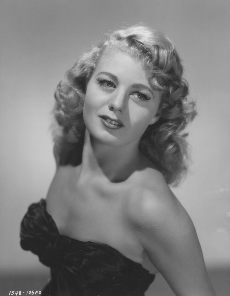 an old black and white photo of a woman in a strapless dress posing for a portrait