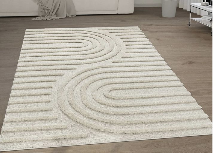 a large white rug with wavy lines on the floor in front of a living room