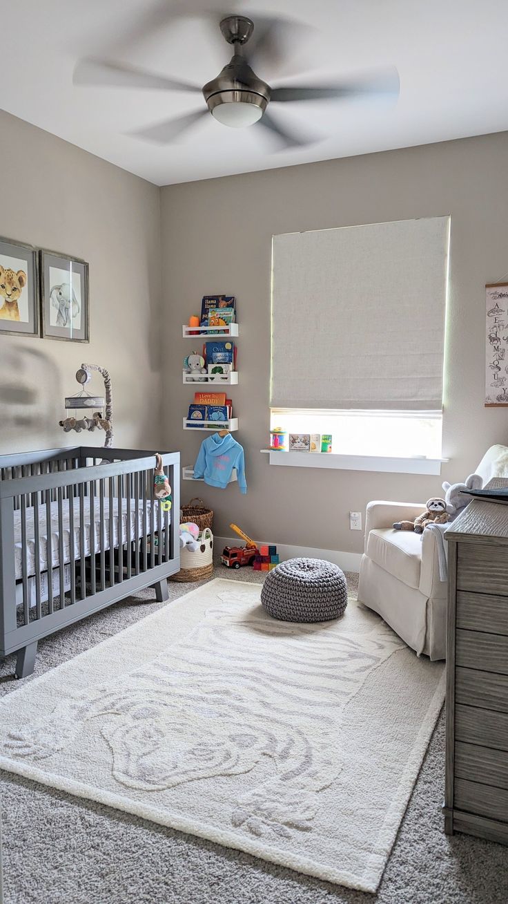 a baby's room with a gray crib and white rug