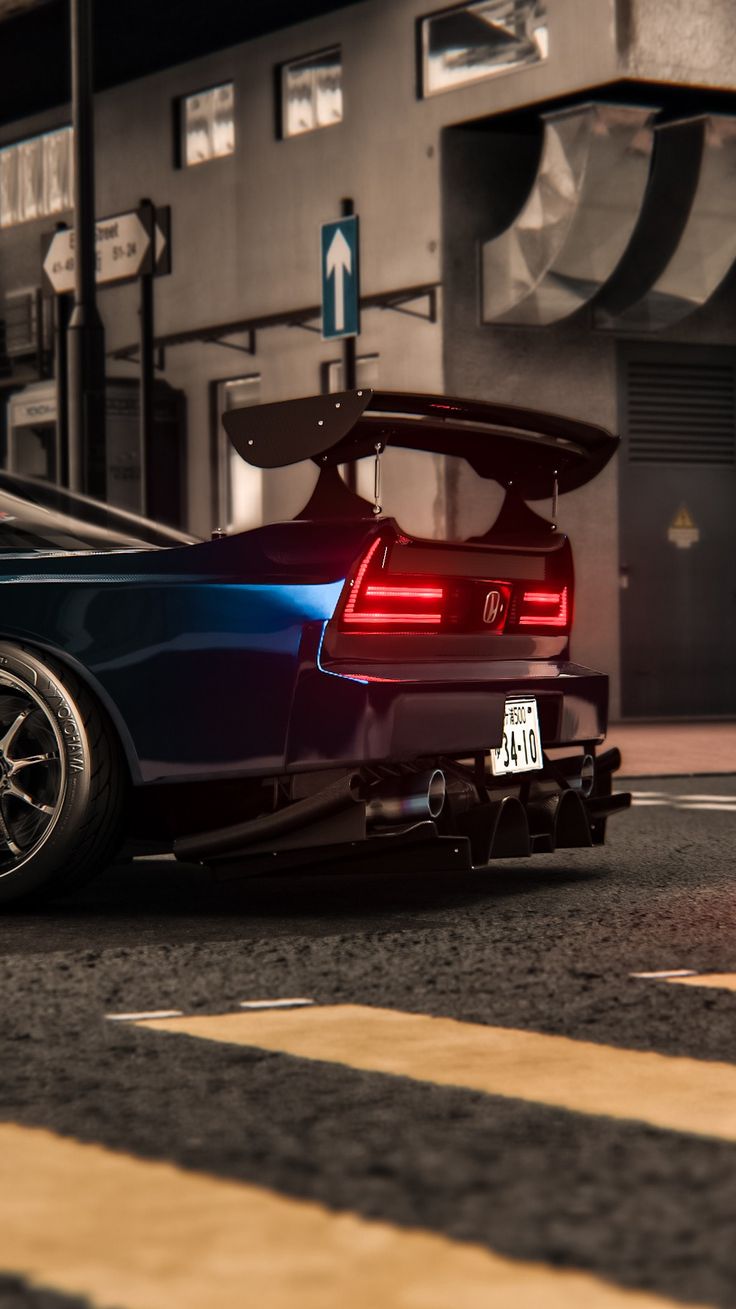 the back end of a blue sports car parked in front of a building