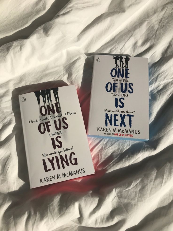 two paperback books sitting on top of a bed next to each other in front of a white sheet