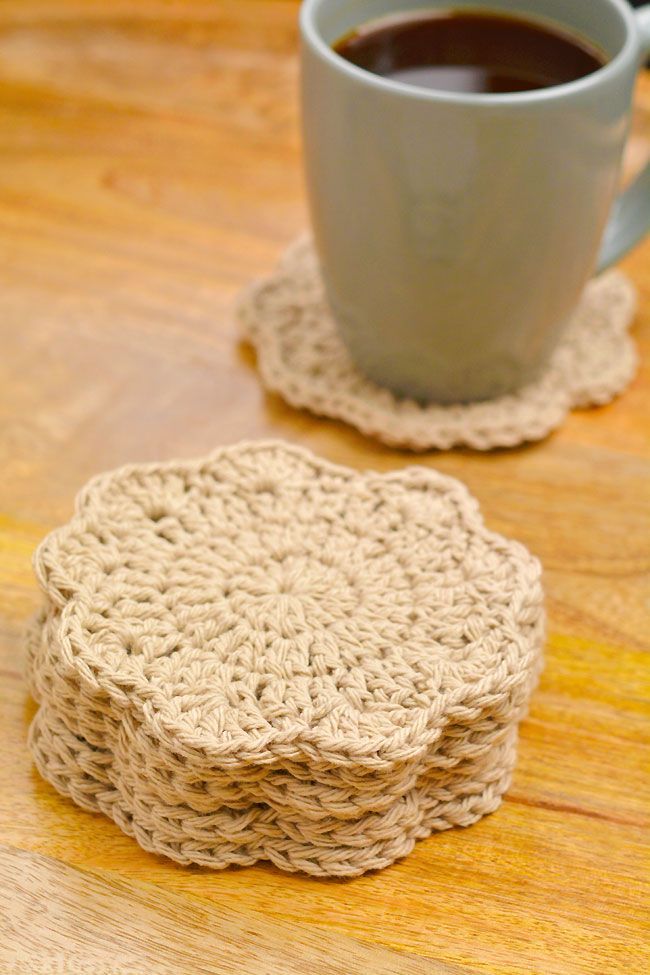 three crocheted coasters sitting next to a cup of coffee