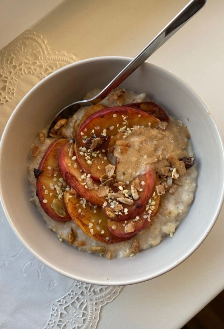 a bowl filled with oatmeal topped with sliced peaches