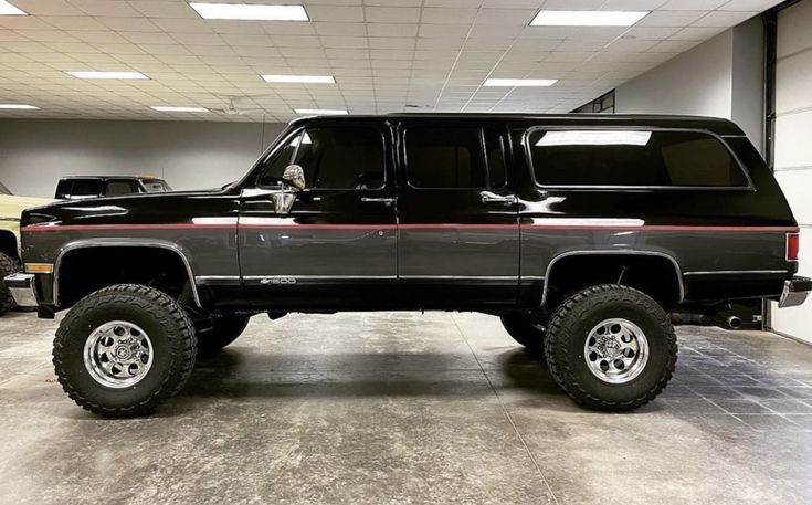 a large black truck parked in a garage