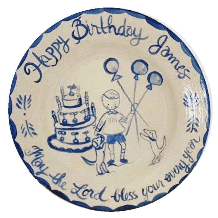 a blue and white plate with an image of a boy holding balloons next to a birthday cake