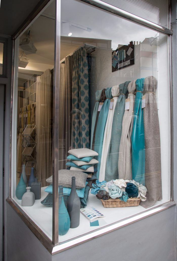 there is a display in the window with blue and white items on it's shelf