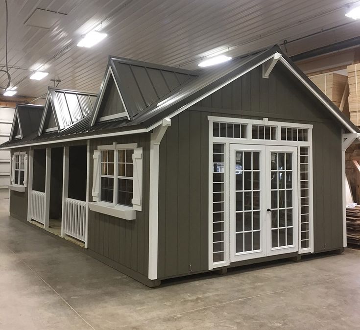 a small house with windows and doors on the roof is in a warehouse or workshop