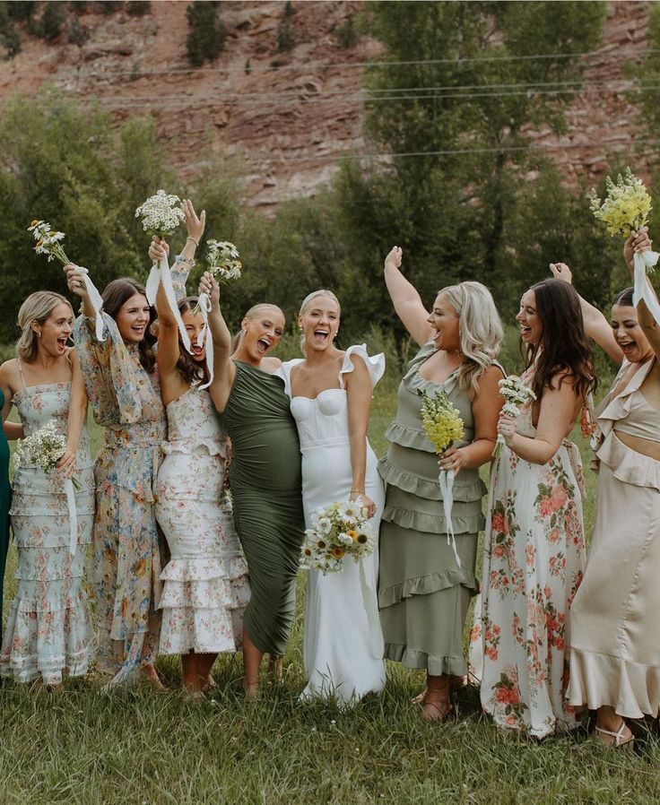 a group of women standing next to each other on top of a lush green field