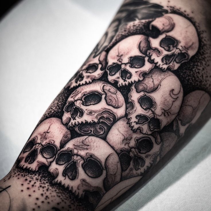 a man's arm with many skulls on it