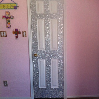 there is a door with glitter on it in the room that has pink walls and wooden floors