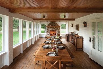 a long wooden table sitting in the middle of a room filled with lots of windows