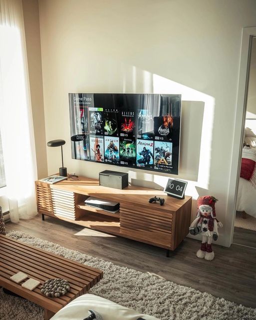 a flat screen tv sitting on top of a wooden entertainment center in a living room