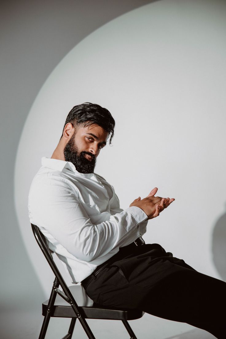 a man sitting in a chair with his hands folded