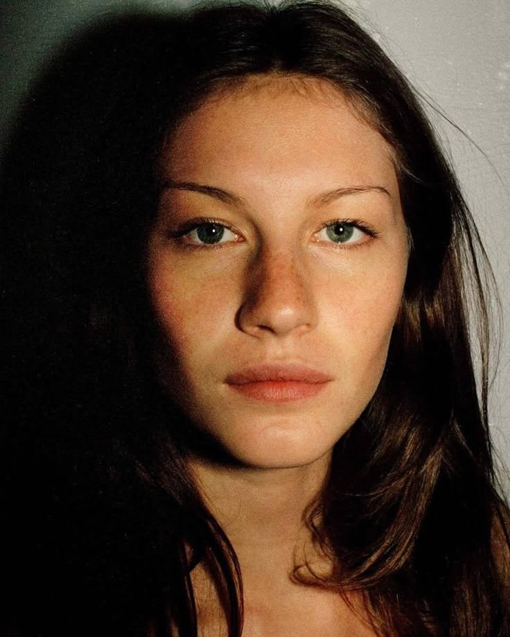 a woman with long brown hair and blue eyes