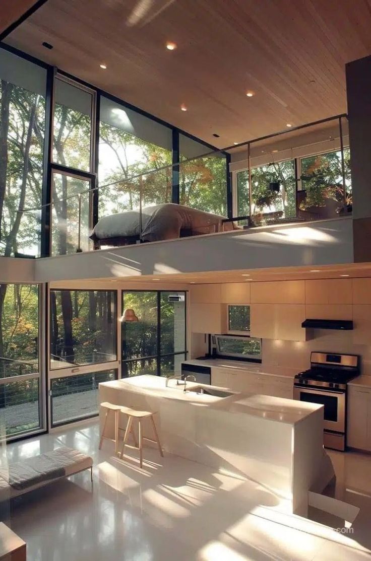 an open kitchen and living room with lots of windows on the side of the house