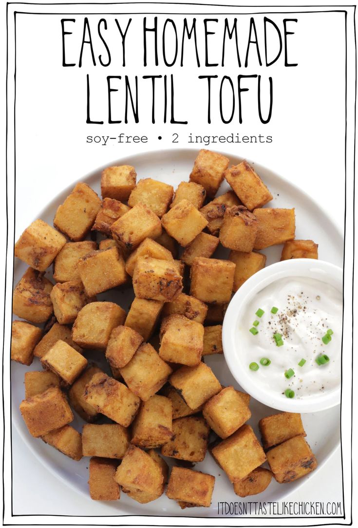 a white plate topped with tofu next to a small bowl of ranch dressing on top of it