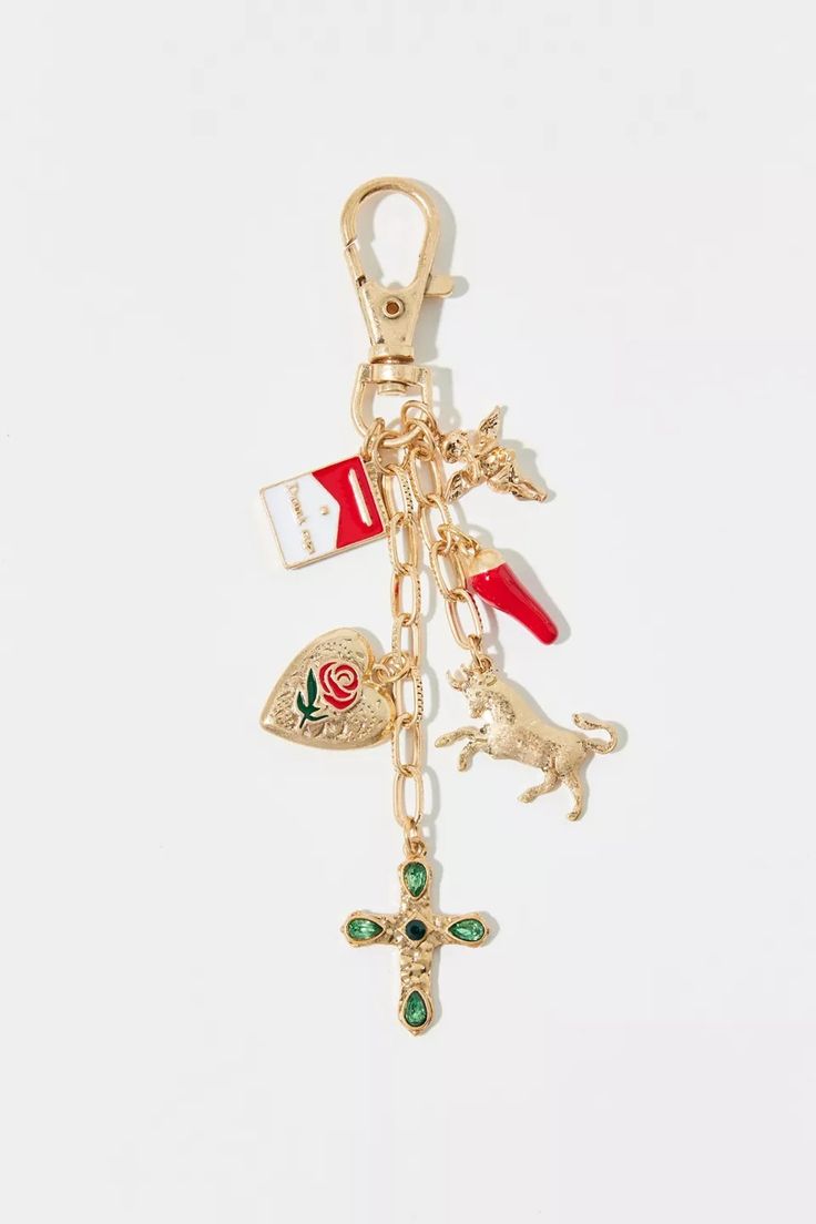 a gold keychain with charms on it, including a cross and other items