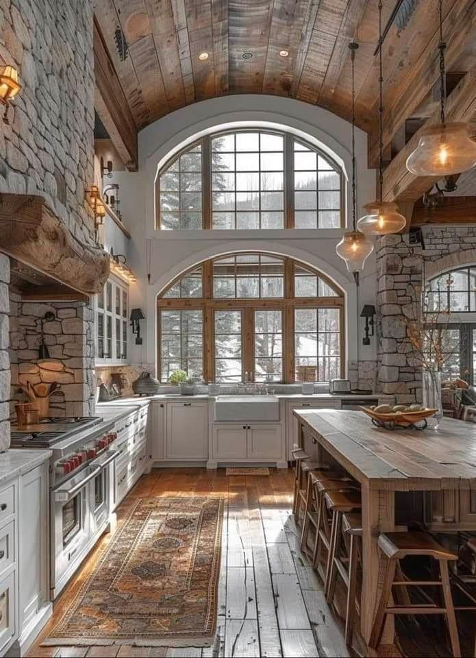 a large kitchen with an arched window and wooden flooring