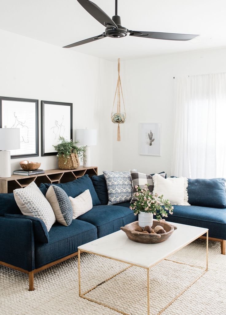 a living room with blue couches and pillows