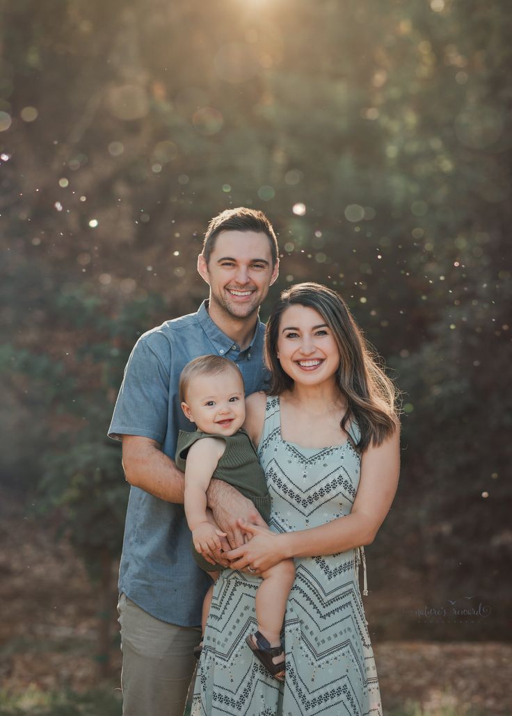 a man and woman holding a baby in their arms