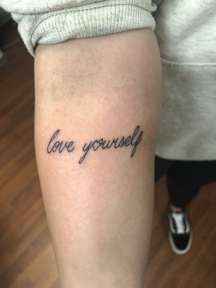 a woman's leg with the words love yourself tattooed on it