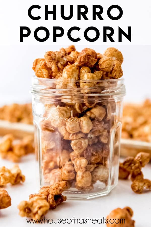 a glass jar filled with popcorn sitting on top of a table