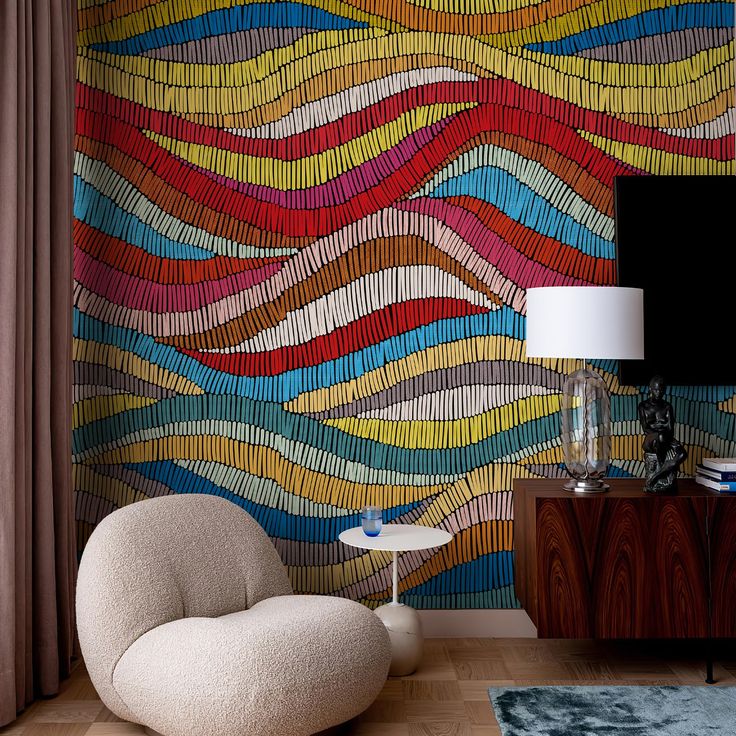 a living room with a large colorful wallpaper and a chair in front of it