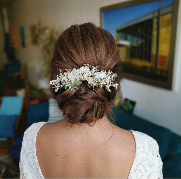 a woman with flowers in her hair wearing a white dress and a flower headpiece