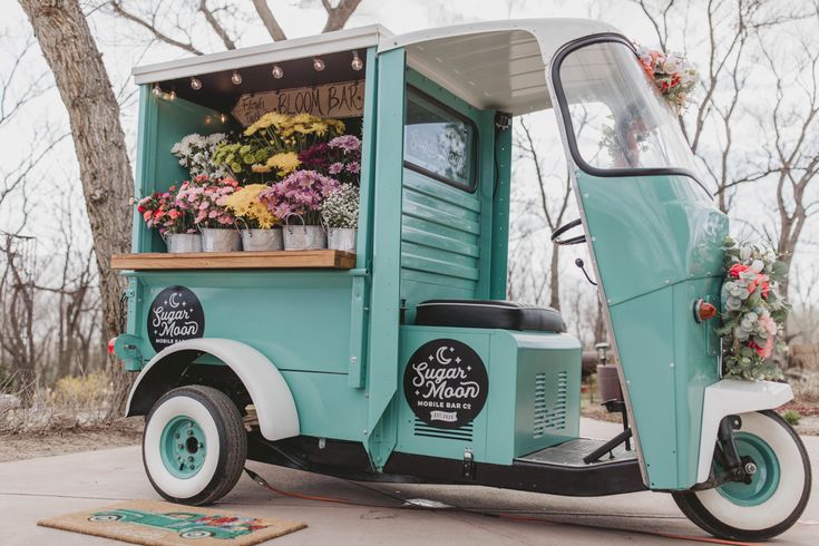 an old truck with flowers in the back