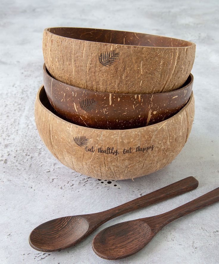 three wooden bowls and two spoons on a table