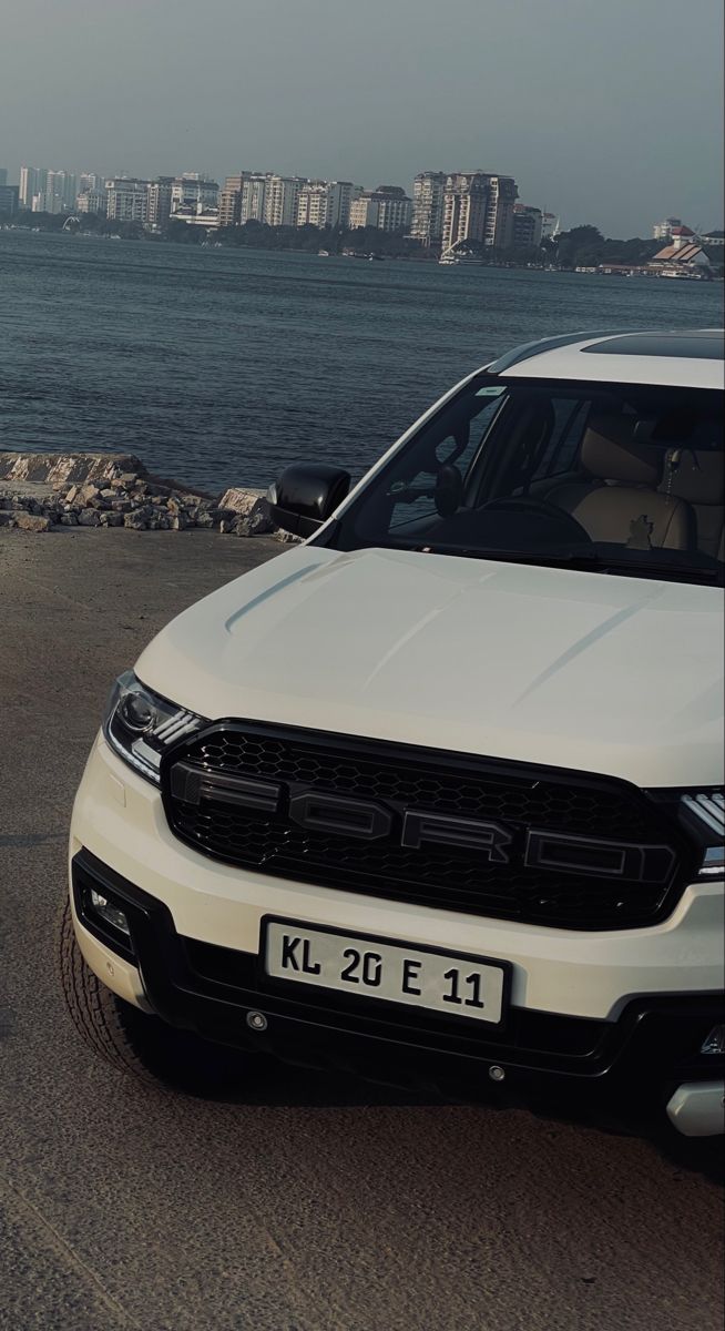 a white truck parked next to the ocean