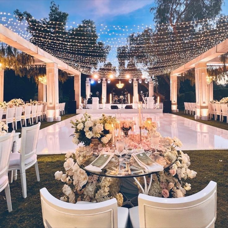 an outdoor venue with tables and chairs set up for a formal function at night time